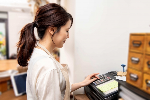 手根管症候群による手のしびれがよくなり、レジ打ちをする女性