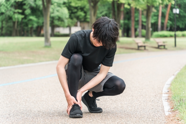 アキレス腱炎でランニングを中止する男性